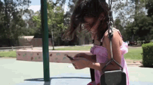 Girl on swing with phone